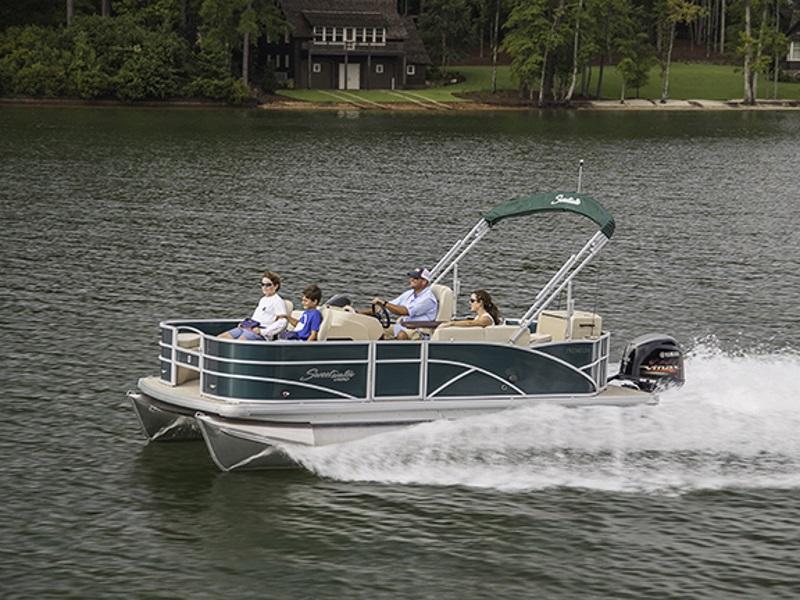 A family on a Sweetwater boat cruising on a lake.